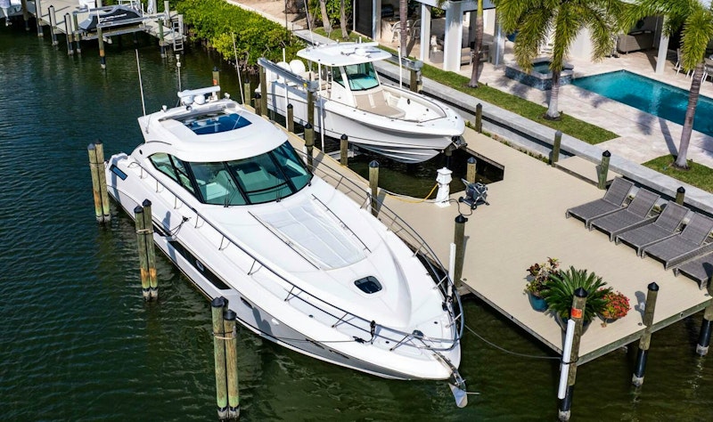 boat for sale on lift behind a house