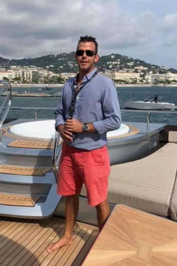 greg standing on yacht